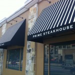 This is a custom striped Sunbrella fabric awning in San Antonio with custom Sunbrella Graphics System lettering at Fleming's Steakhouse Job location: San Antonio